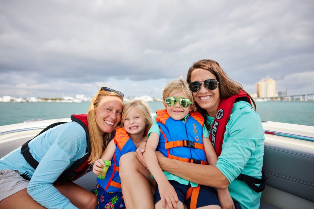 Happy women and children wearing lifejackets on a boat, boating in Ontario concept.