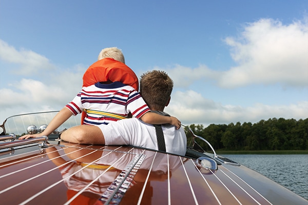 Father and son enjoying a boat ride after buying a boat for the first time.