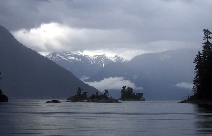 A lake with small islands and mounts in the background.