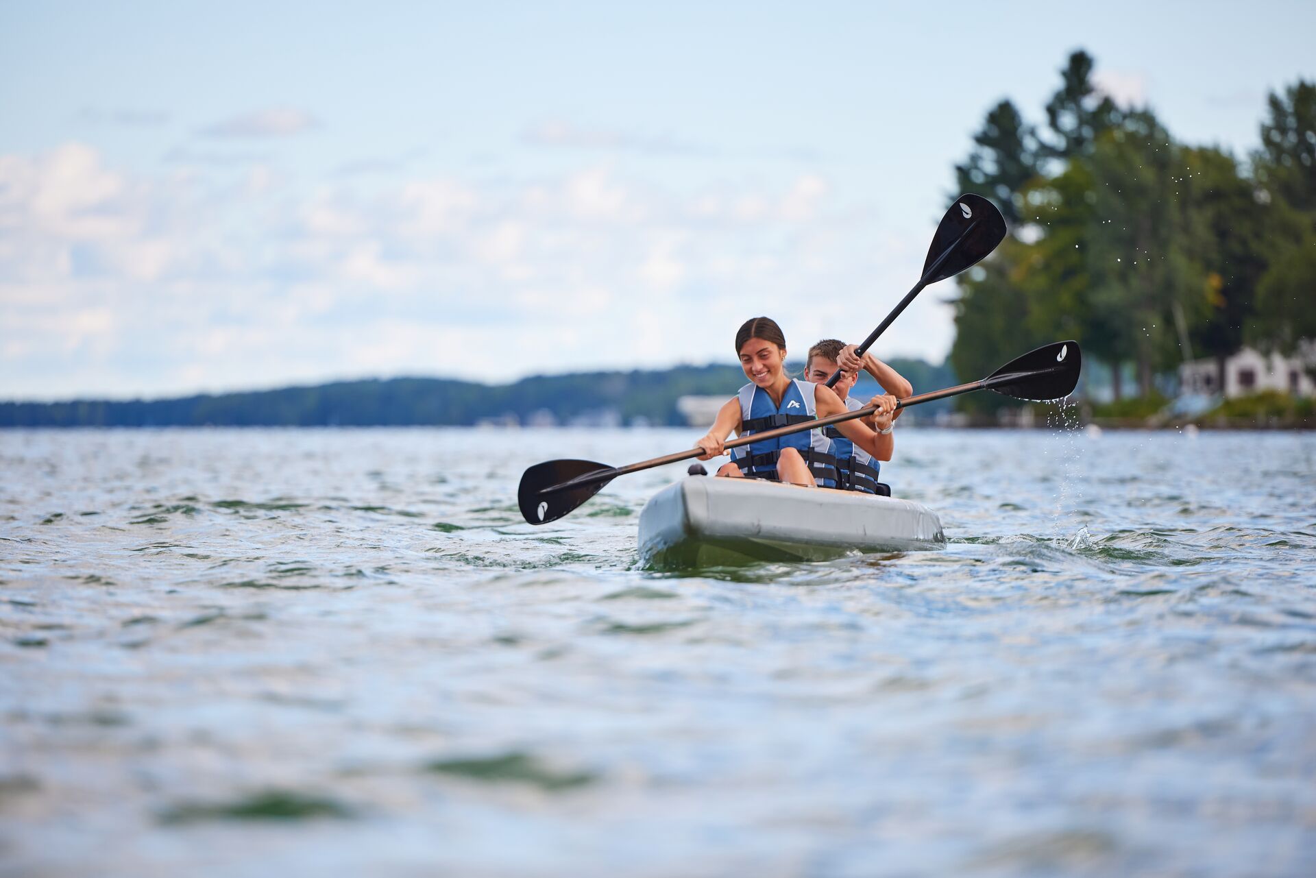 Two people paddle a kayak, boating in Hawaii concept.
