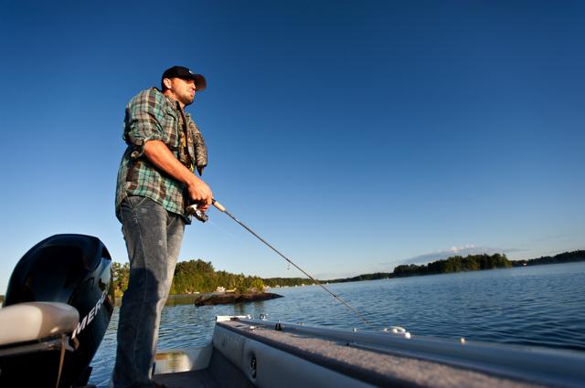 A man with a fishing rod on a boat, fishing in California concept.