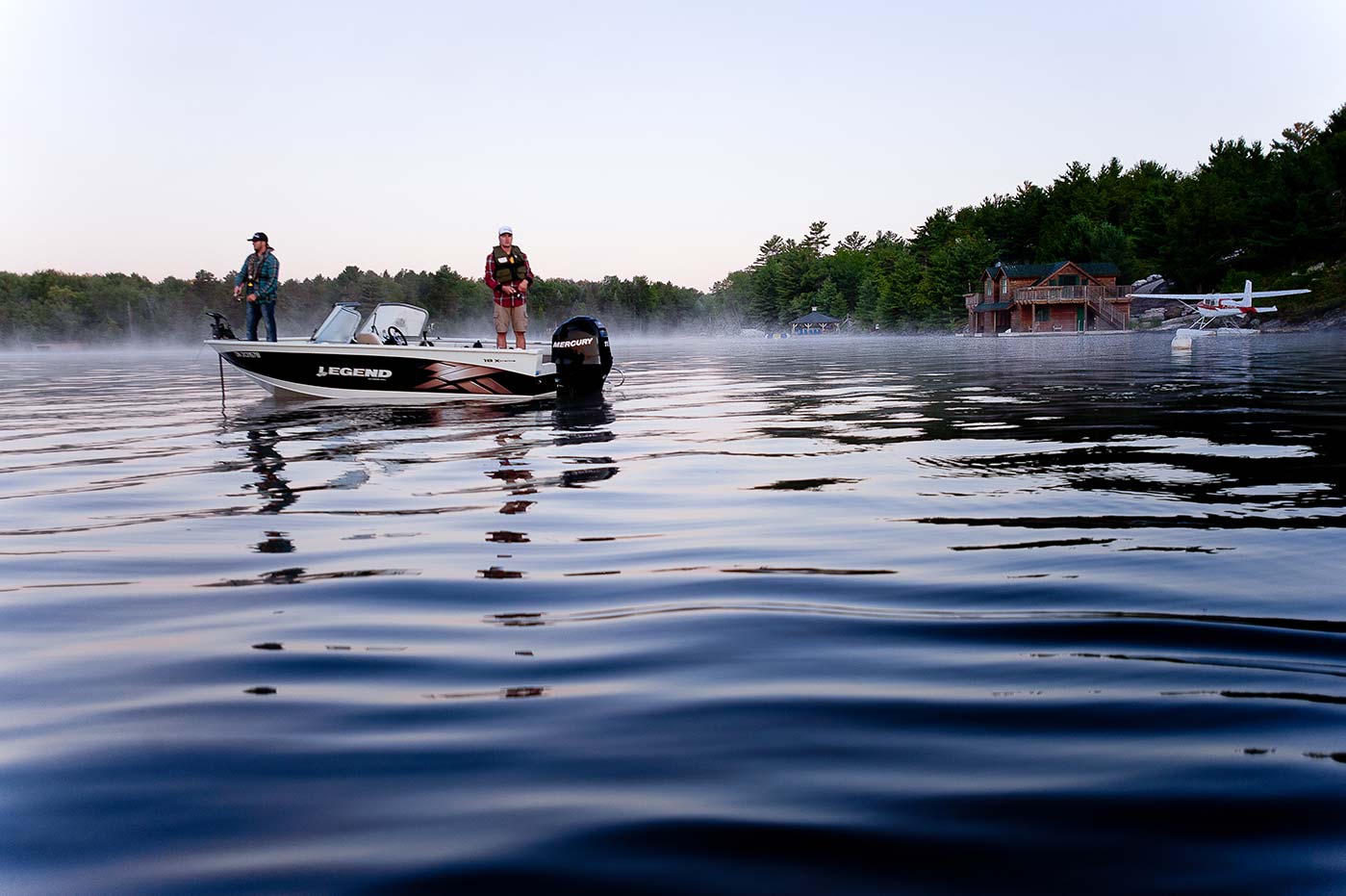 Two people in a fishing boat with a light fog on the water, fishing in Newfoundland concept. 