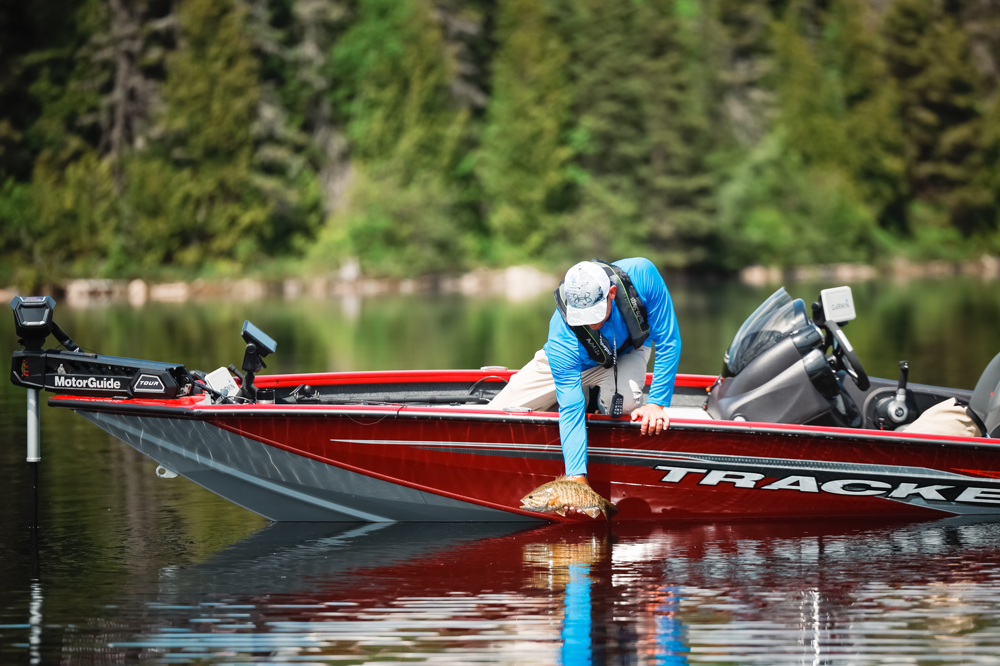 A man on a fishing boat pulls a fish out of the water, fishing and boating in Oklahoma concept.