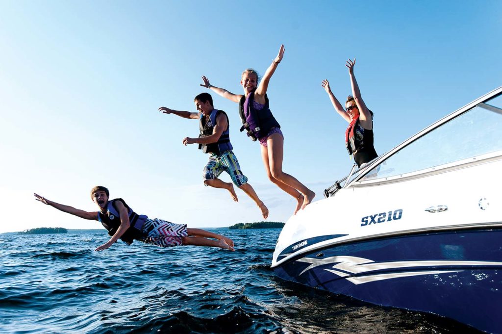 Boaters jumping from a boat into the water while wearing life jackets, boat registration concept.