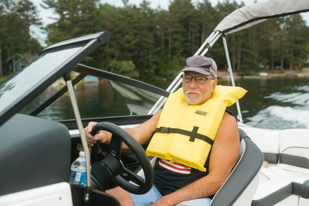A man drives a boat while wearing a life jacket, boat registration Ohio concept. 