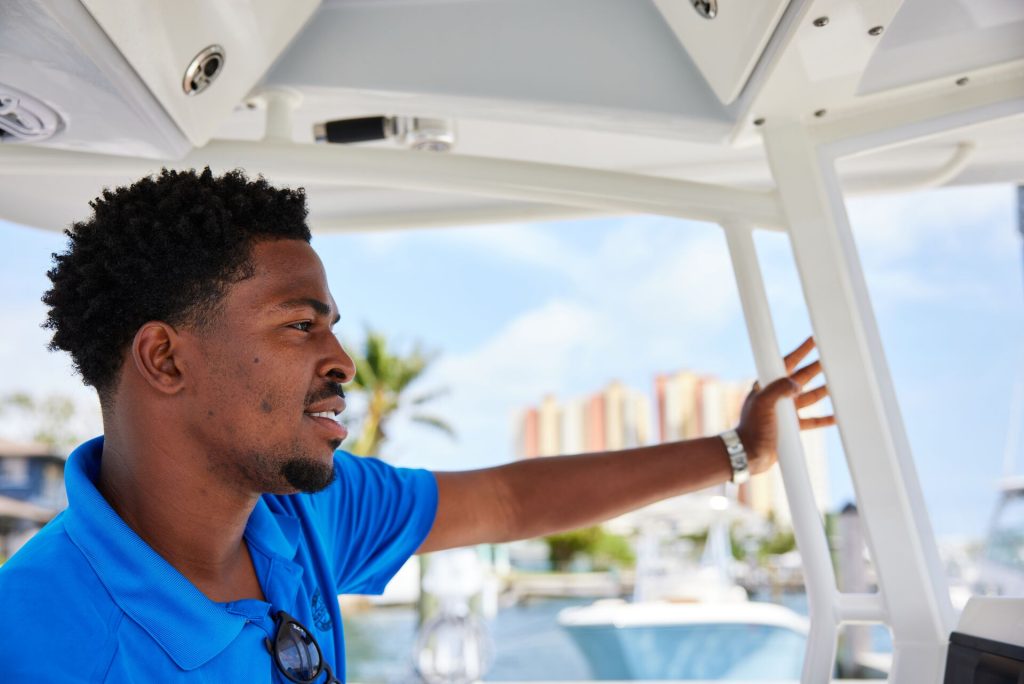 A man smiling while driving a boat in Canada. 