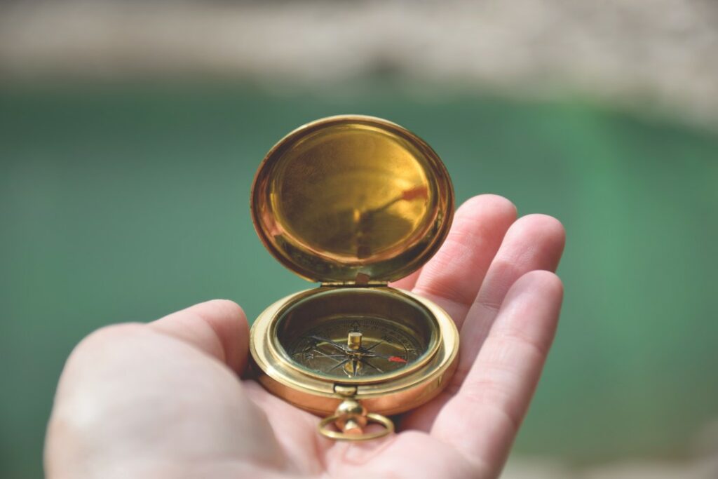 A hand holding a compass, gifts for boaters concept.