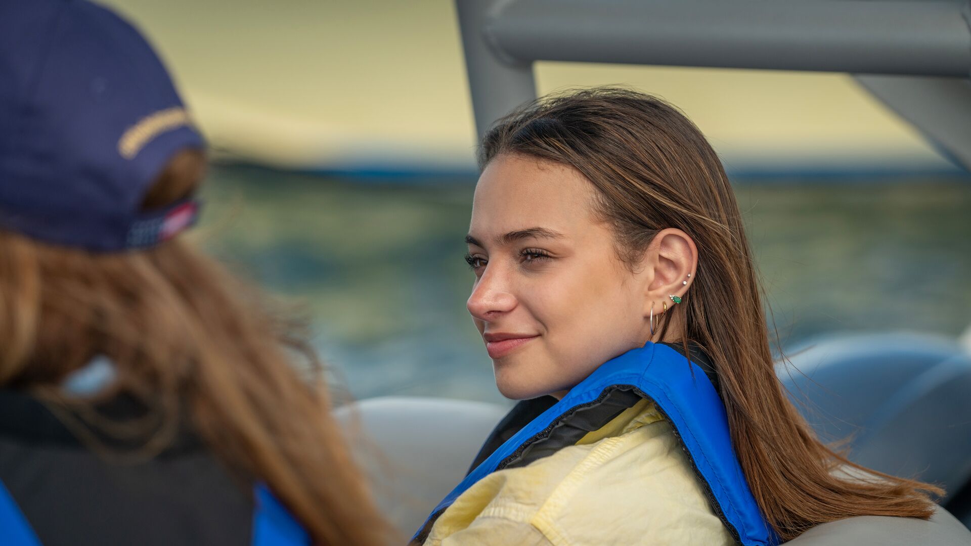 A woman on a boat while wearing a life jacket, learn about Hawaii boating laws for life jackets concept. 
