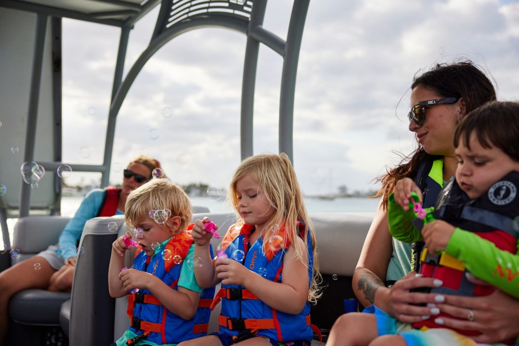 Women and children on a boat wearing lifejackets, boat safety concept.