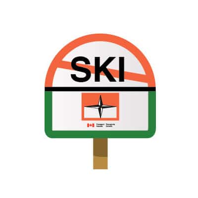 Sign with the word SKI crossed out by an orange slash, above a green-bordered panel with a compass symbol and the Transport Canada logo