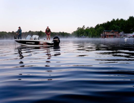 Two fishermen in boat with pontoon plane in background