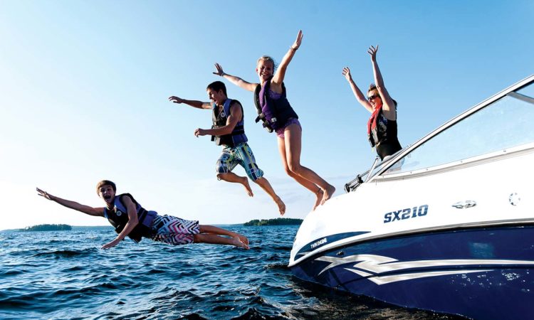 Boaters wearing lifejackets jumping into the water